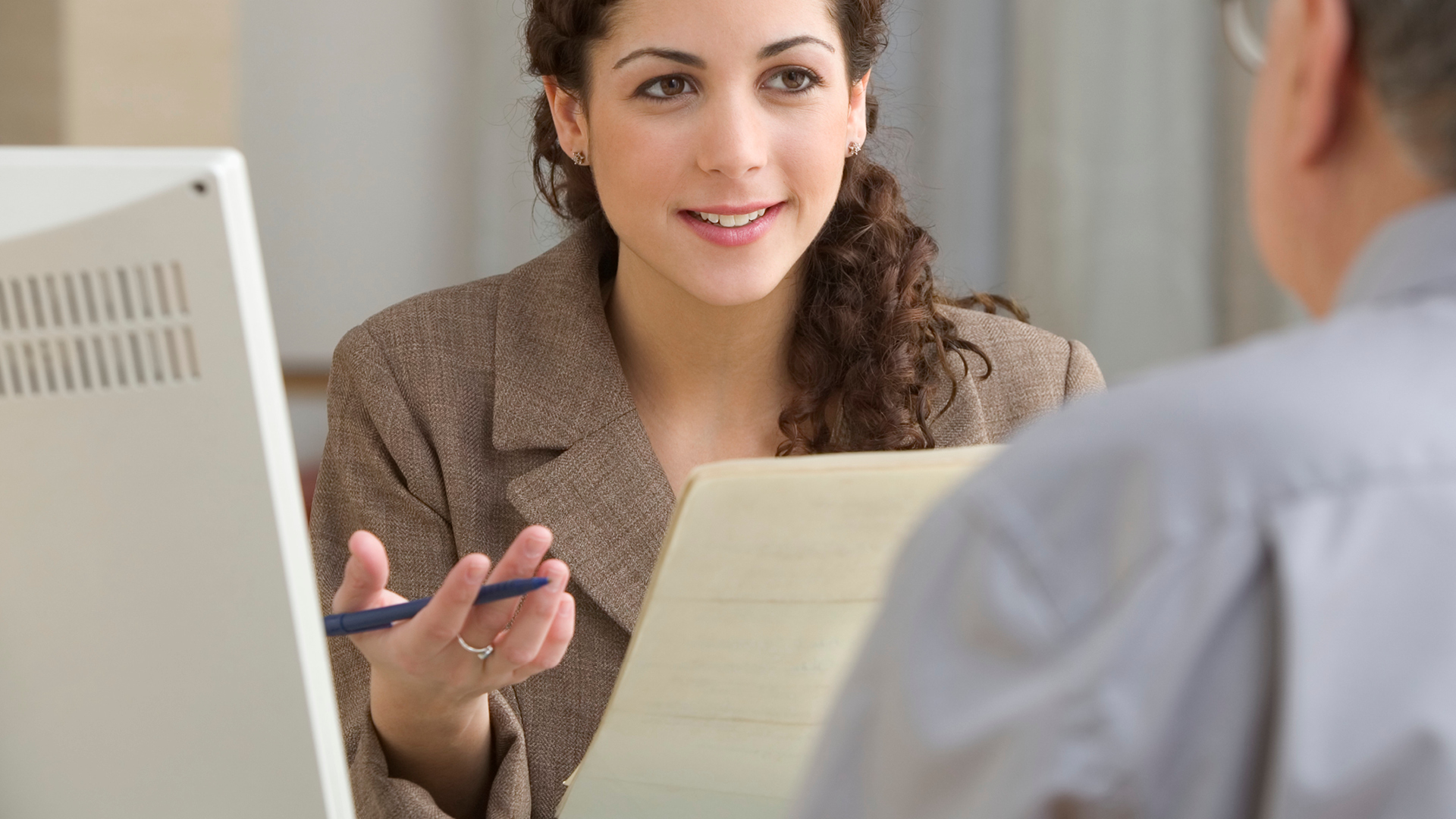 Personalumbau Eine Frau hält einen Stift in der Hand und schaut auf ein Blatt Papier