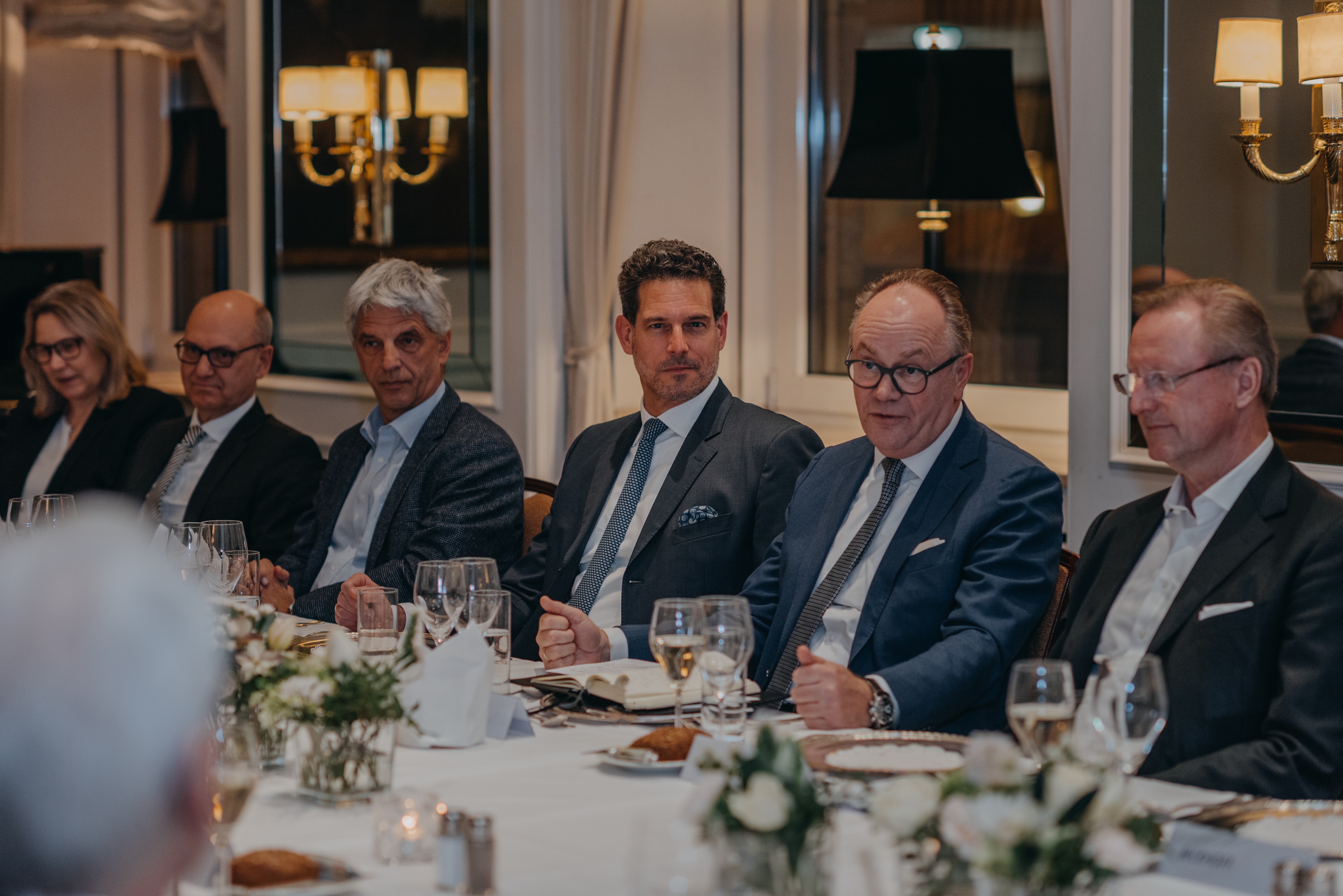 a group of men sitting at a table a group of men sitting at a table
