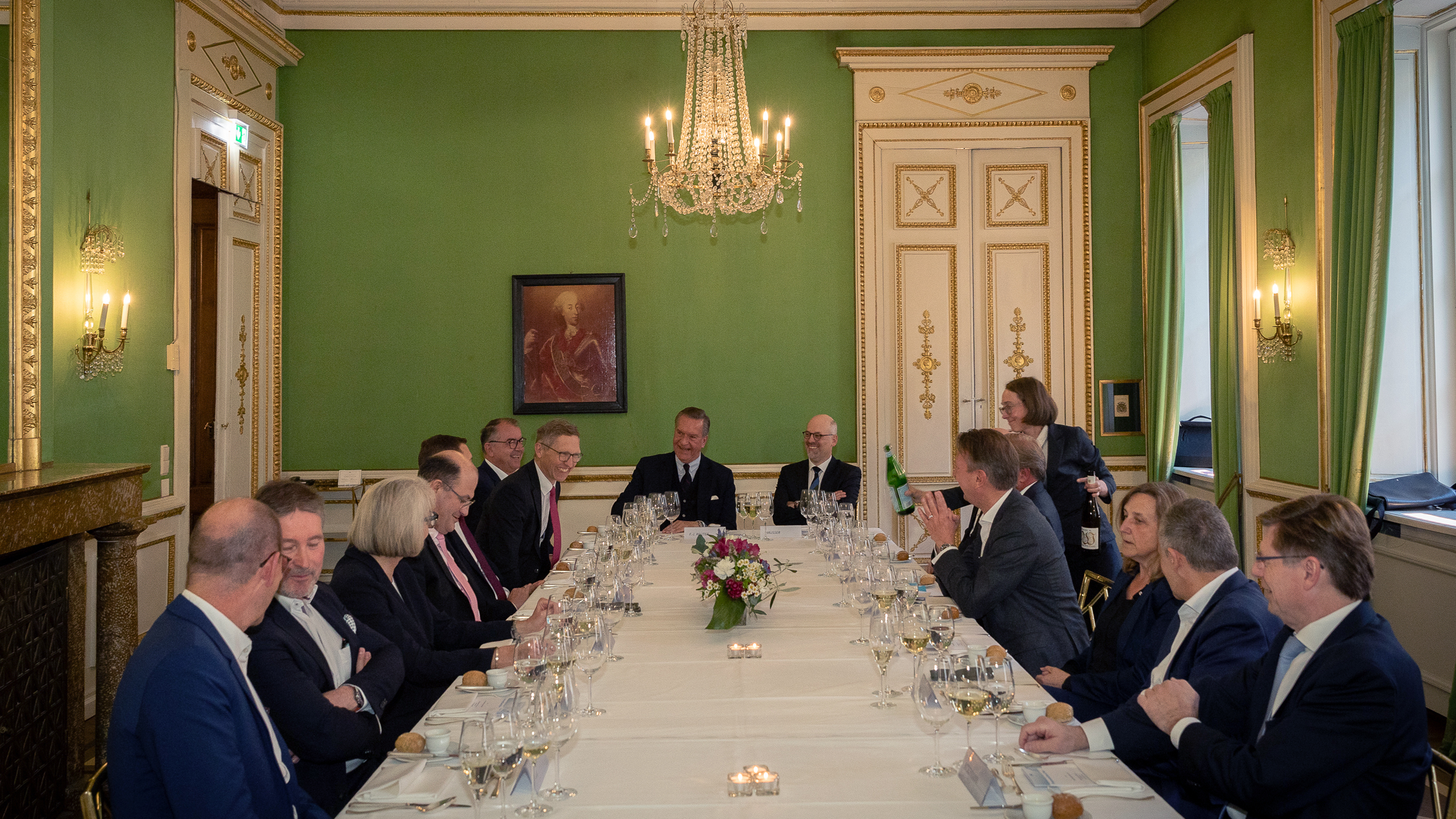a group of people sitting at a long table a group of people sitting at a long table