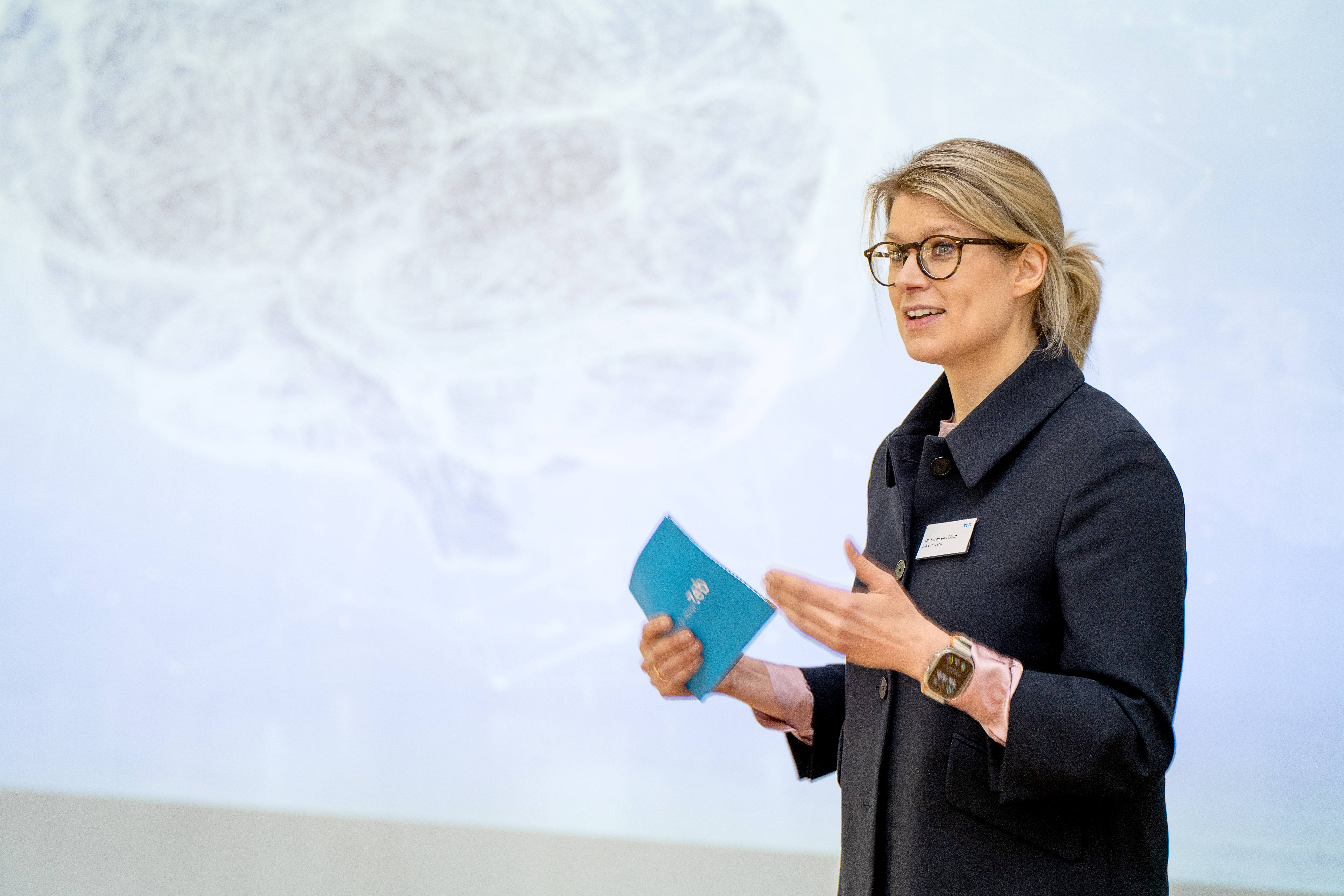 a woman standing in front of a screen a woman standing in front of a screen