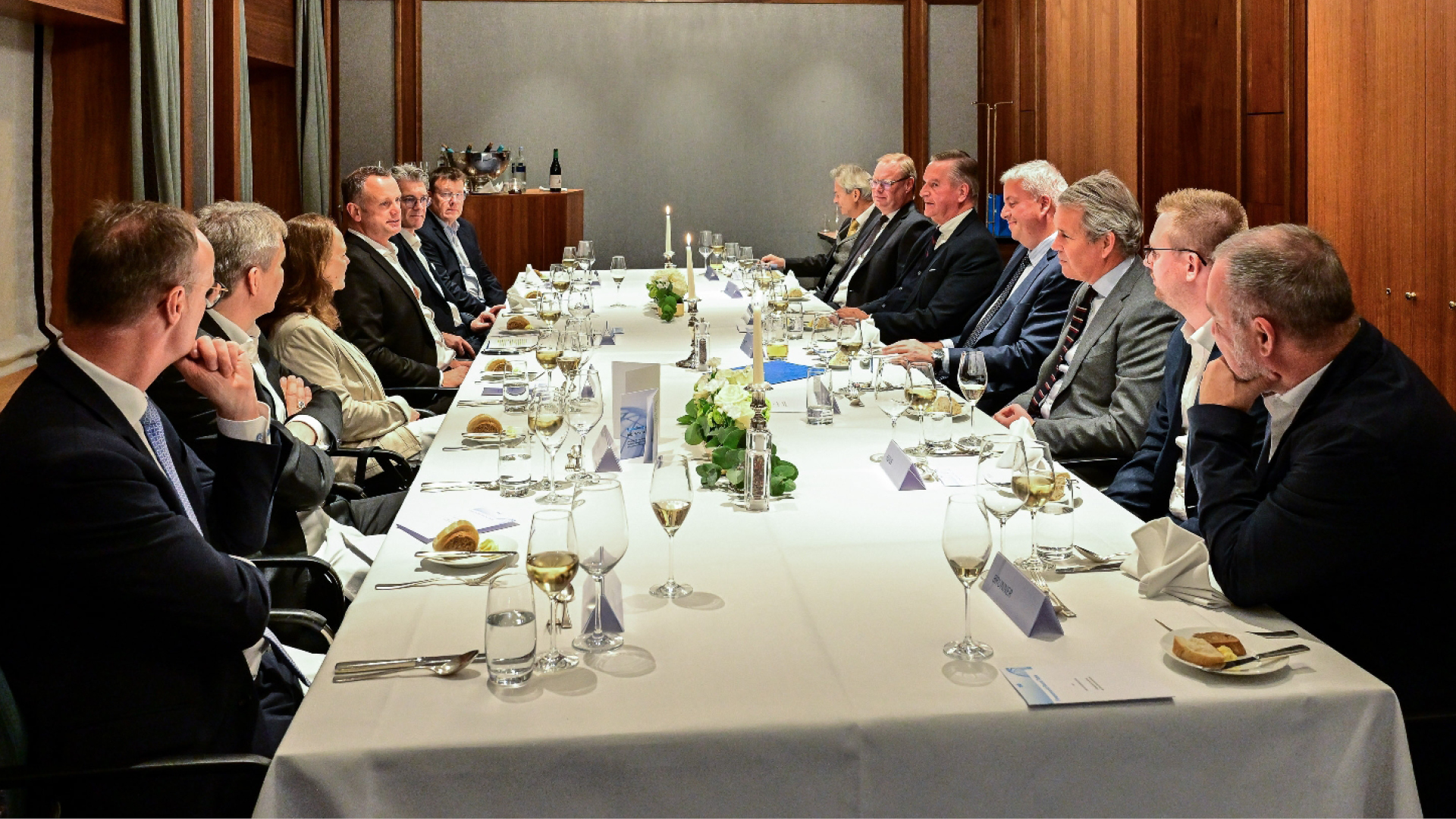 a group of people sitting at a long table a group of people sitting at a long table