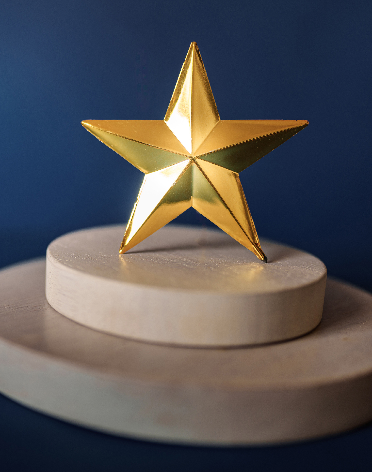 ein goldener Stern auf einer runden Holzplattform