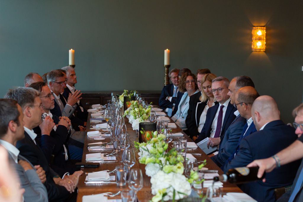 a group of people sitting at a long table
