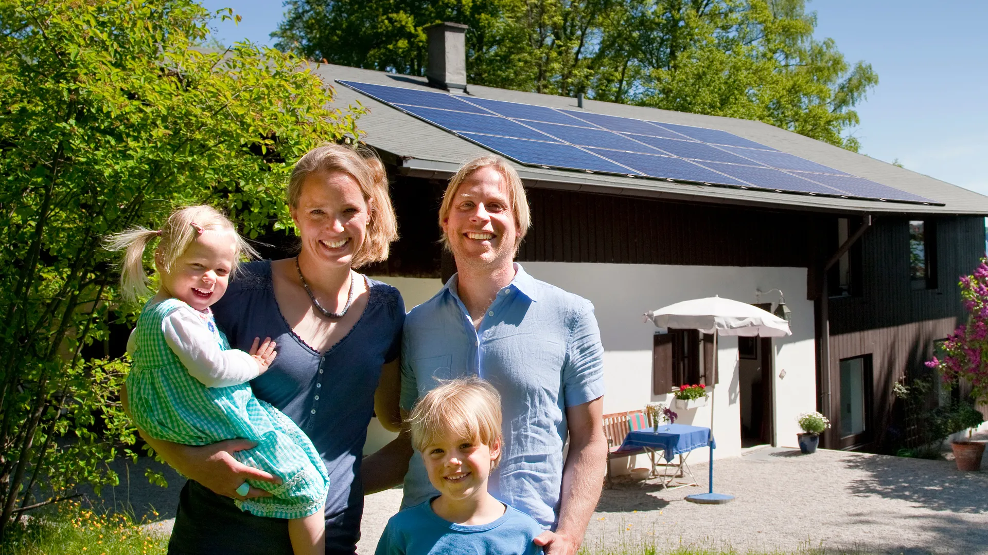 a family posing for a photo in front of a house a family posing for a photo in front of a house