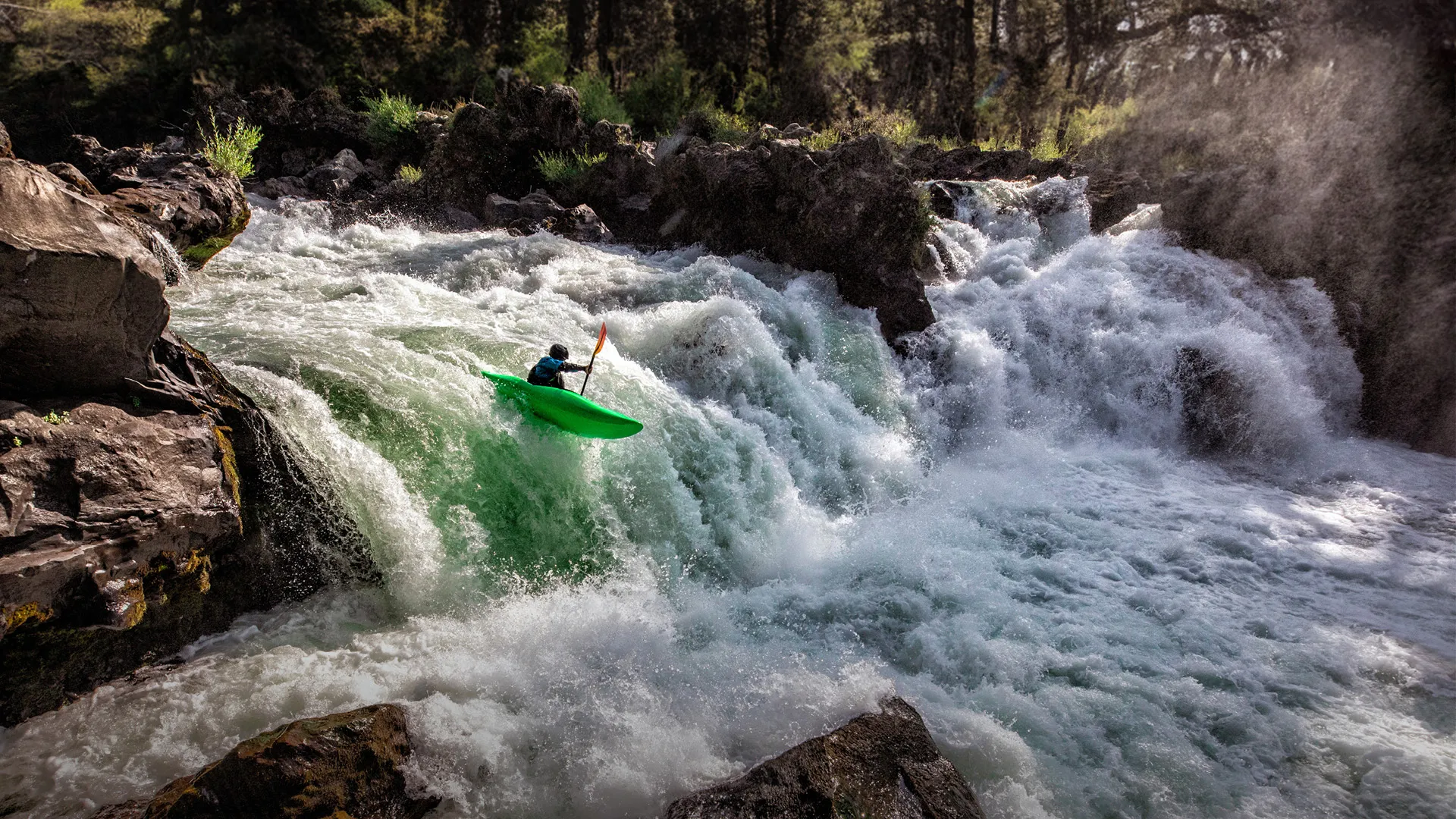 a person in a kayak on a waterfall