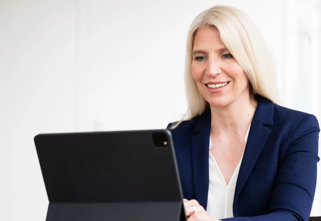 a woman smiling at a laptop