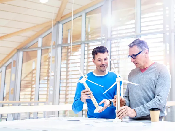 nachhaltigkeit-ist-mehr-als-ein-trend_1920x1080.jpg a group of men looking at windmill model