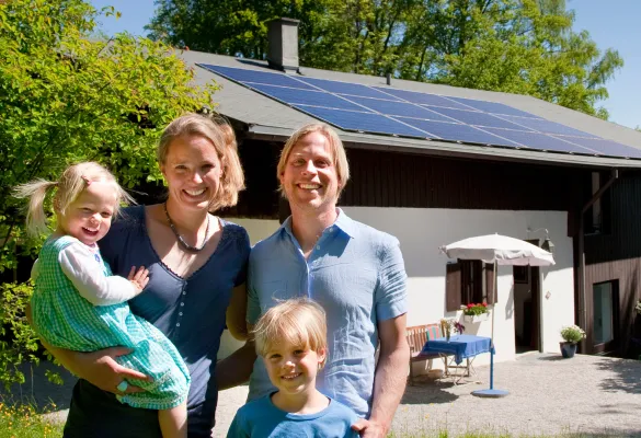 a family posing for a photo in front of a house a family posing for a photo in front of a house
