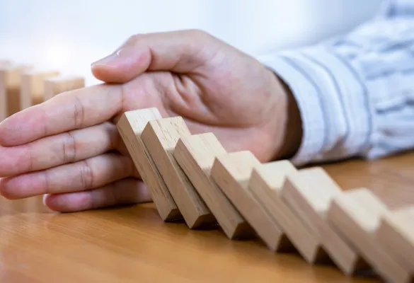 a hand stopping a domino effect a hand stopping a domino effect