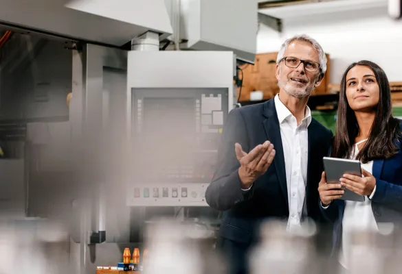 a man and woman standing in a factory