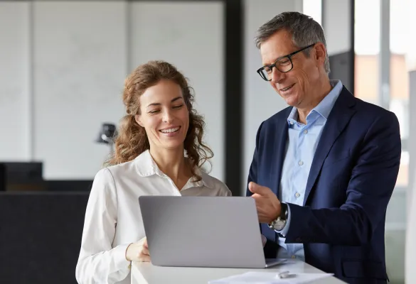 Ein Mann und eine Frau, die auf einen Laptop schauen