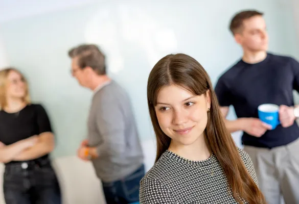 Eine Frau, die mit anderen Leuten hinter sich lächelt