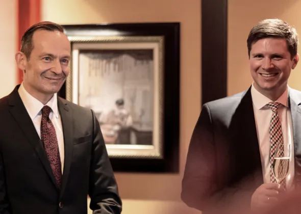 Zwei Männer in Anzügen lächeln