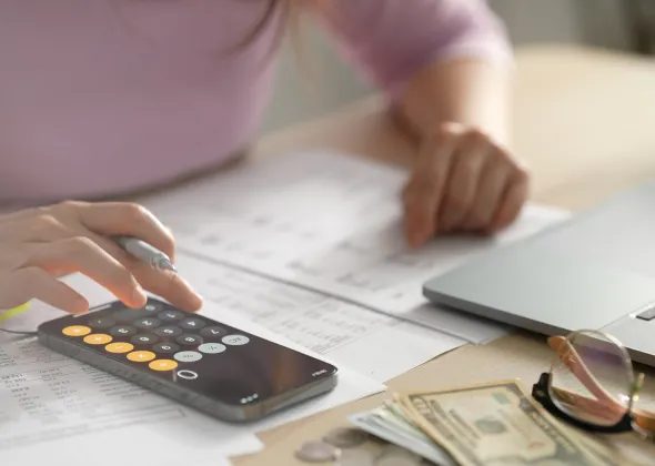 a person using a calculator and a laptop