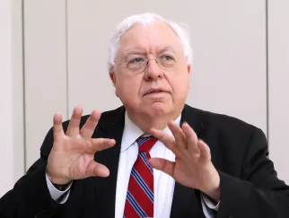 Ein Mann in Anzug und Krawatte hält die Hände hoch