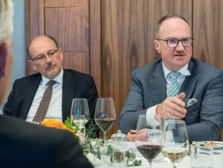 a group of men sitting at a table with wine glasses