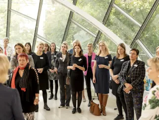 Eine Gruppe von Frauen, die in einem Raum mit Fenstern stehen