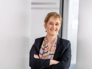 a woman with short hair wearing a suit and scarf