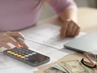 a person using a calculator and a laptop
