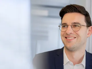a man wearing glasses and a suit a man wearing glasses and a suit