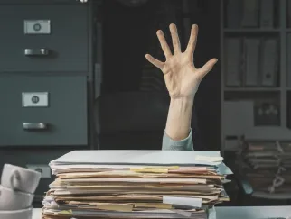 a hand reaching out to a stack of files