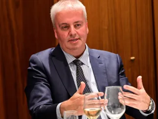 a man in a suit and tie talking to another man