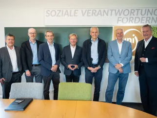 sieben Männer stehen im Halbkreis