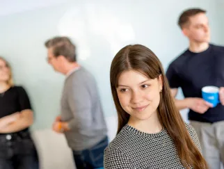 Eine Frau, die mit anderen Leuten hinter sich lächelt