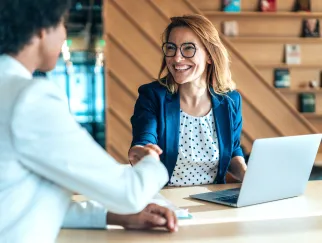Eine Frau, die einer anderen Frau die Hand schüttelt