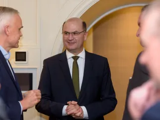 Eine Gruppe Männer in Anzügen schüttelt Hände