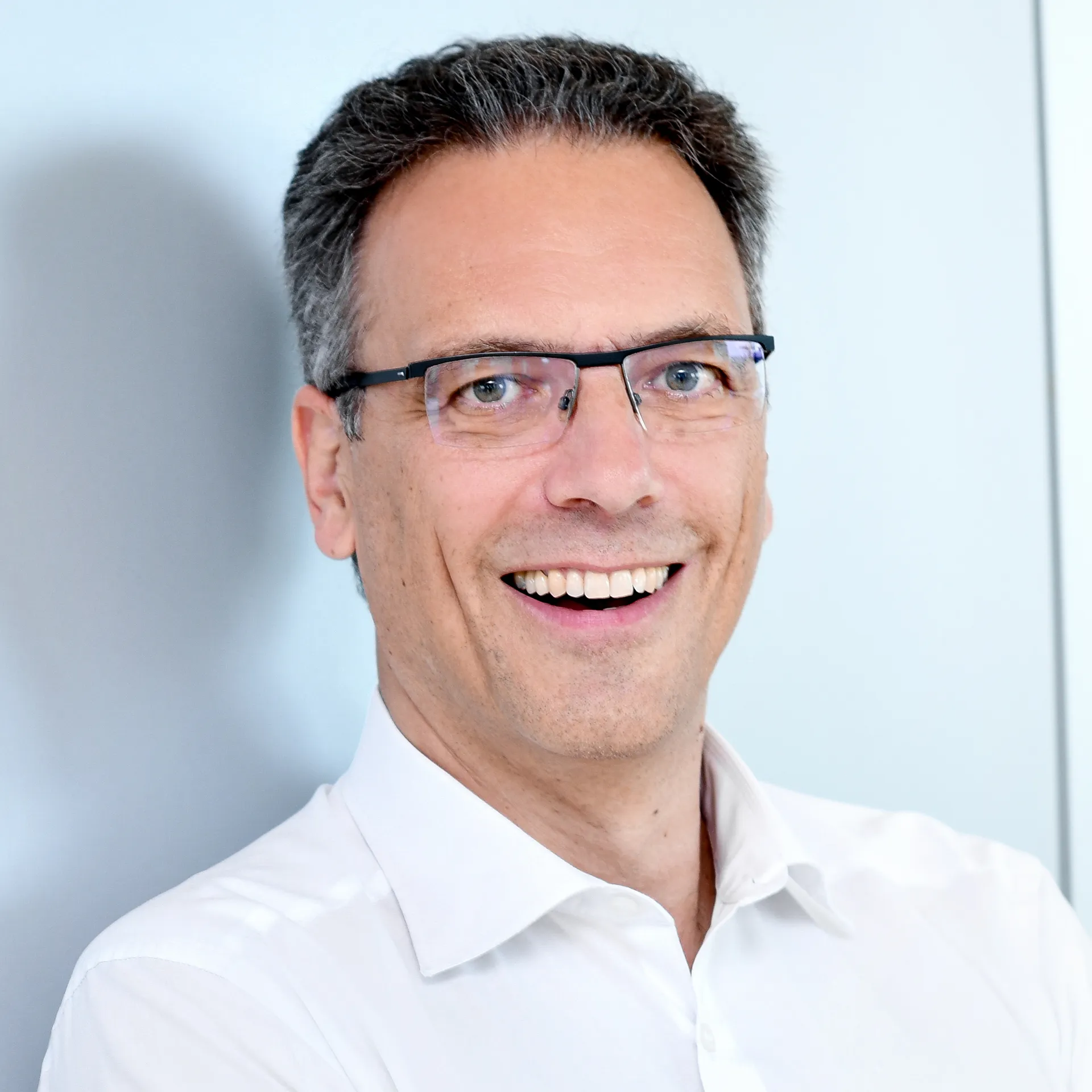 a man wearing glasses smiling