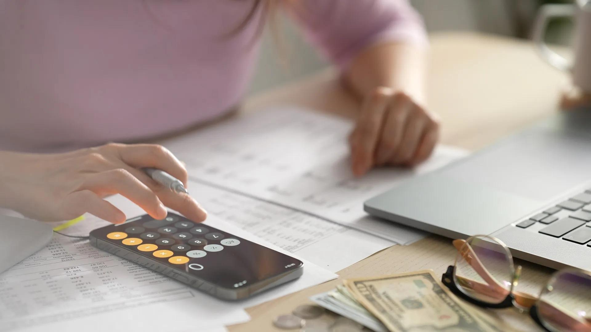 a person using a calculator and a laptop