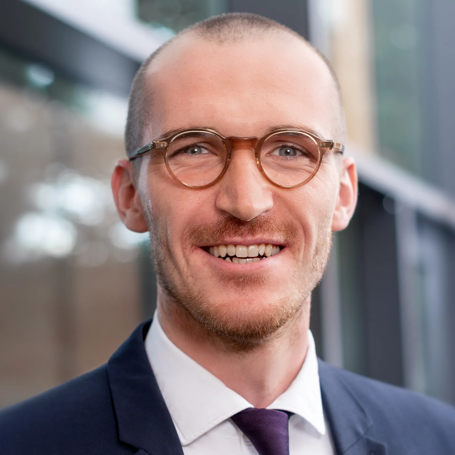 a man wearing glasses and a suit