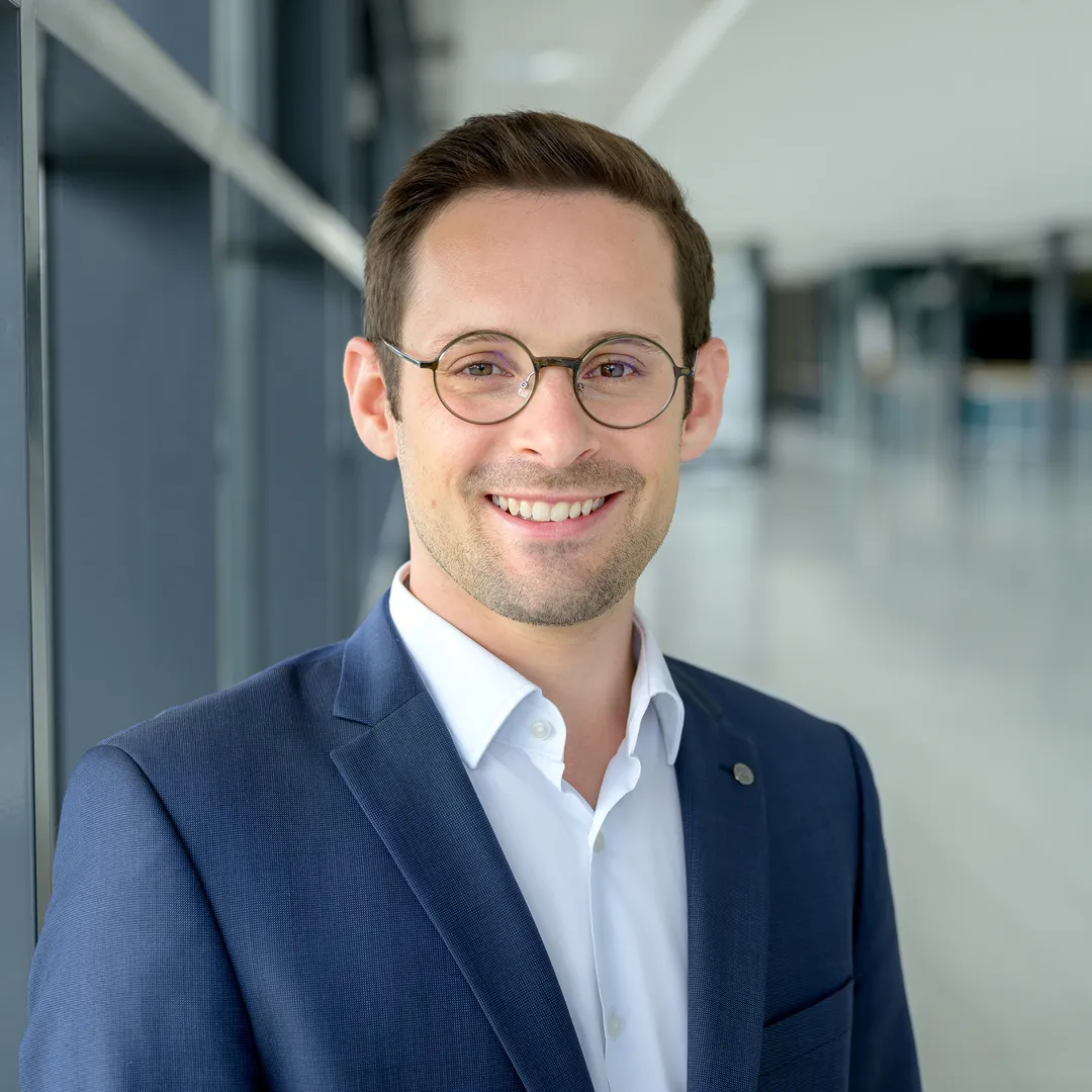 a man wearing glasses and a suit