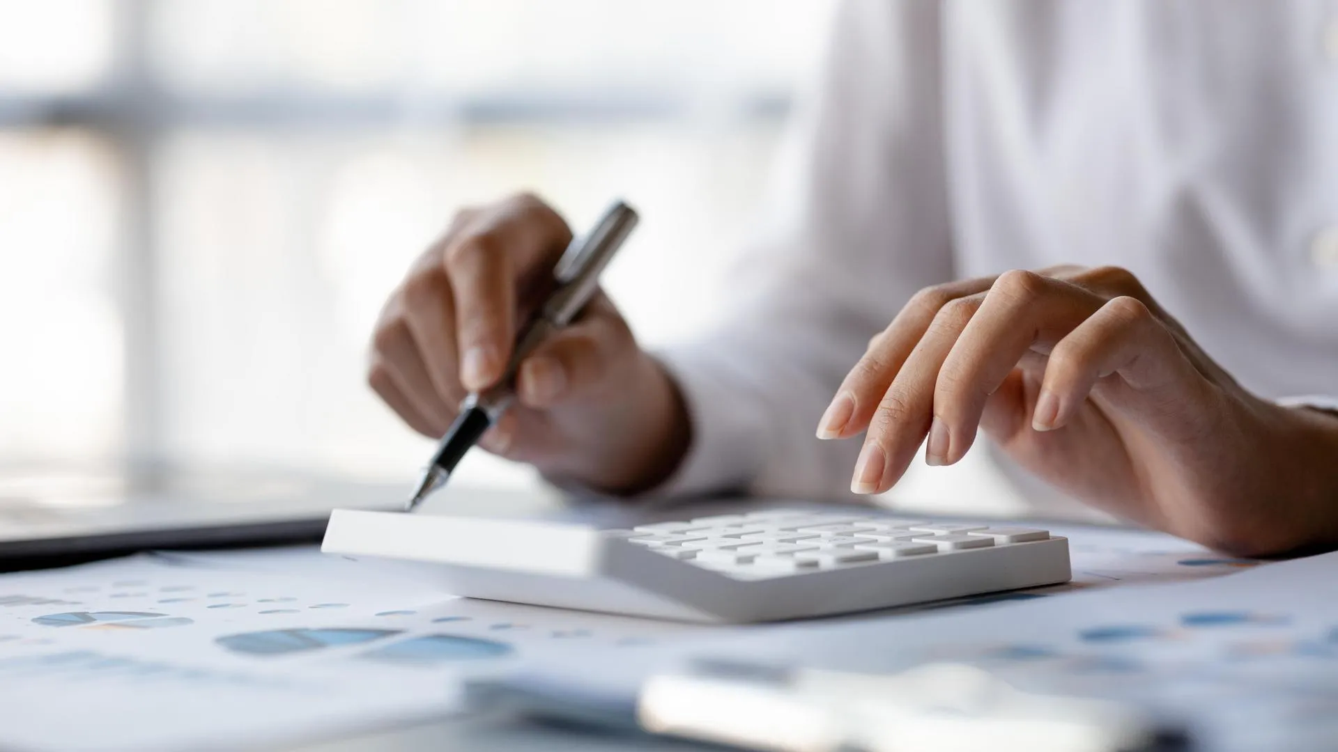 a person using a calculator and pen