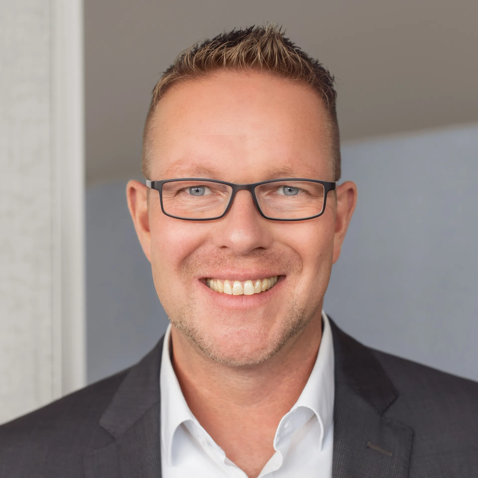 a man wearing glasses and a suit
