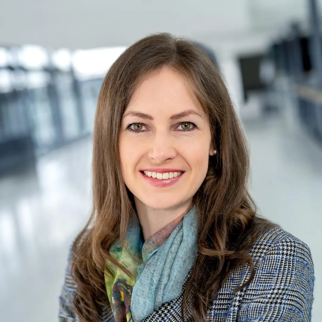 Eine Frau, die in die Kamera lächelt