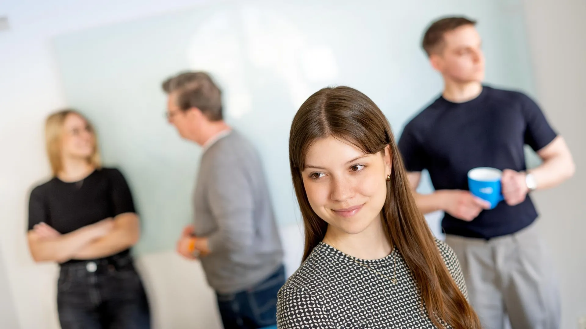 Eine Frau, die mit anderen Leuten hinter sich lächelt
