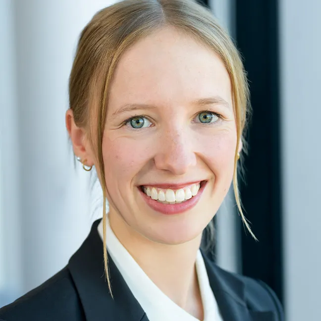 Eine Frau, die in die Kamera lächelt