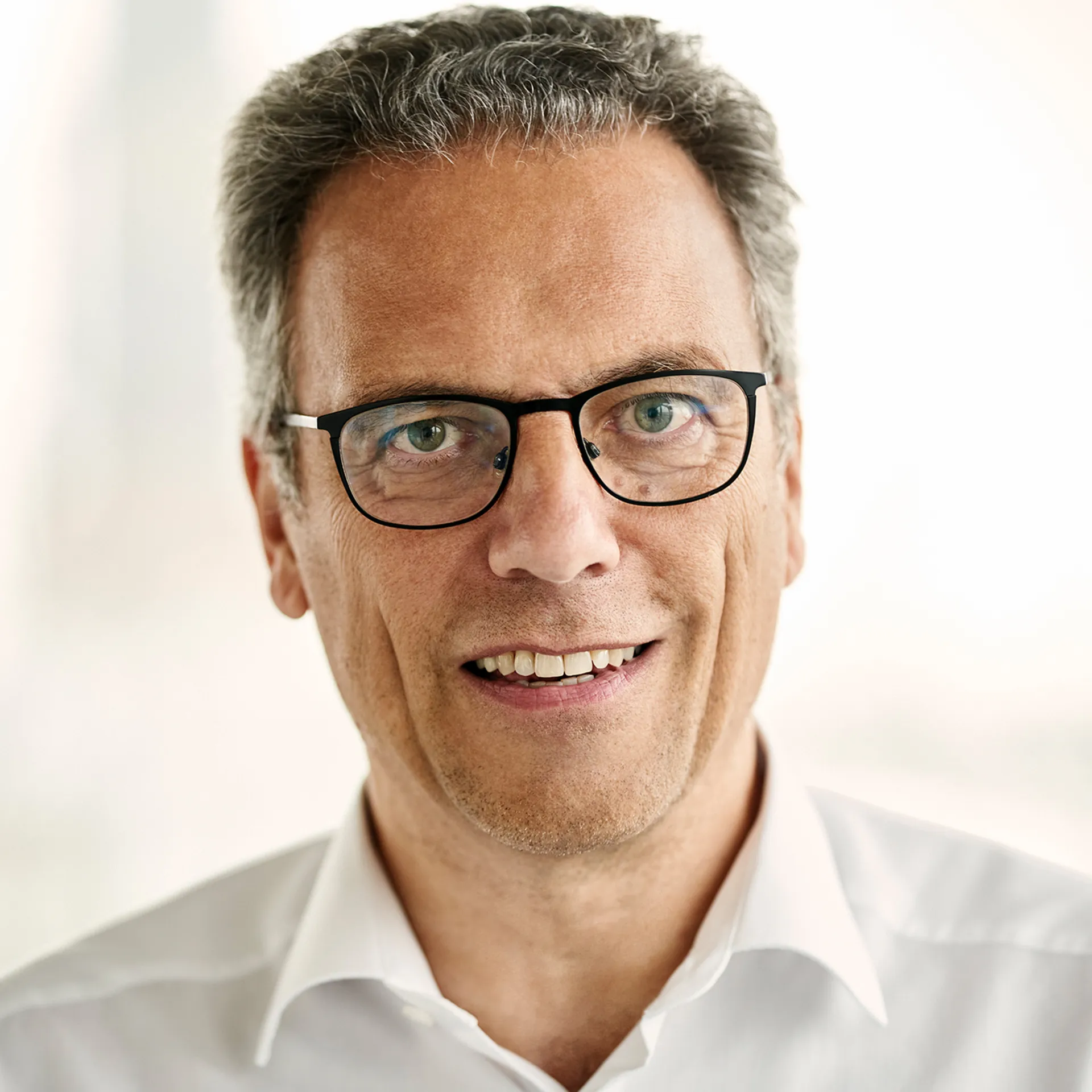 a man wearing glasses and a white shirt