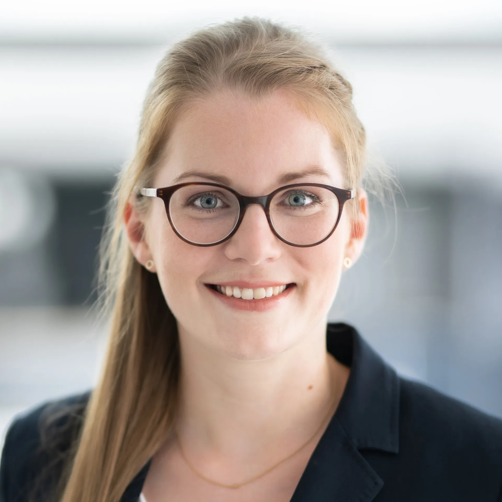 a woman wearing glasses and a black jacket