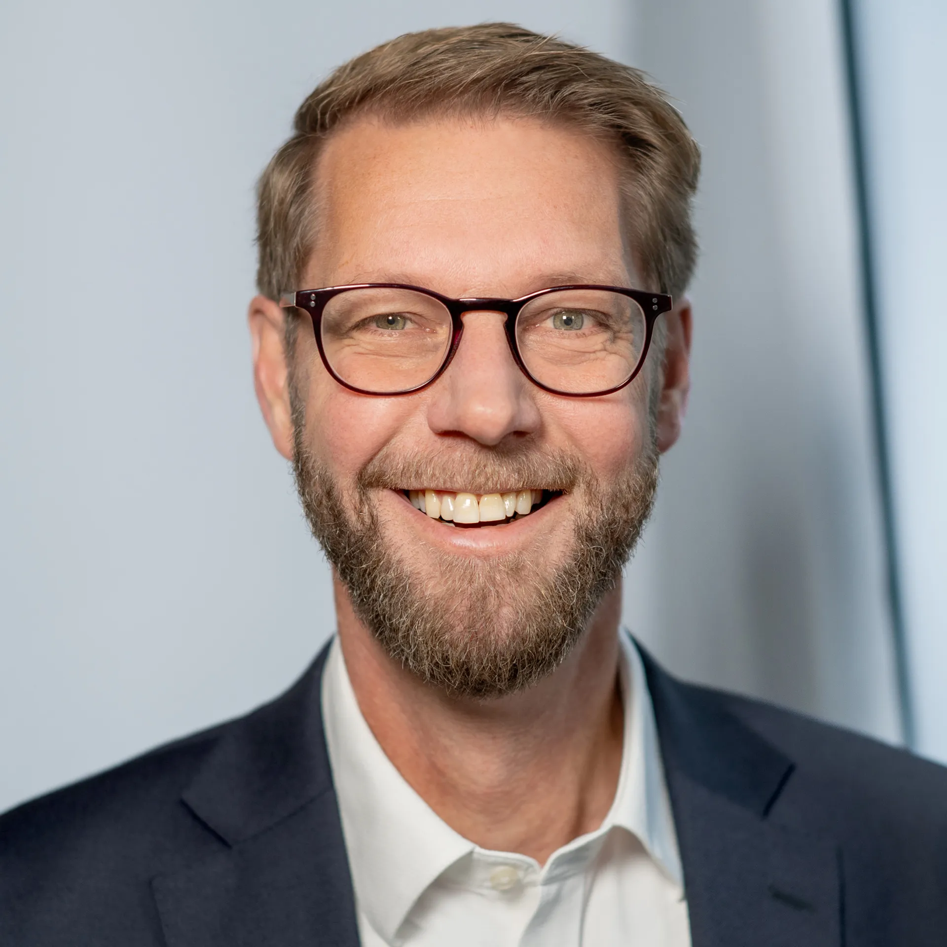 a man wearing glasses and a suit