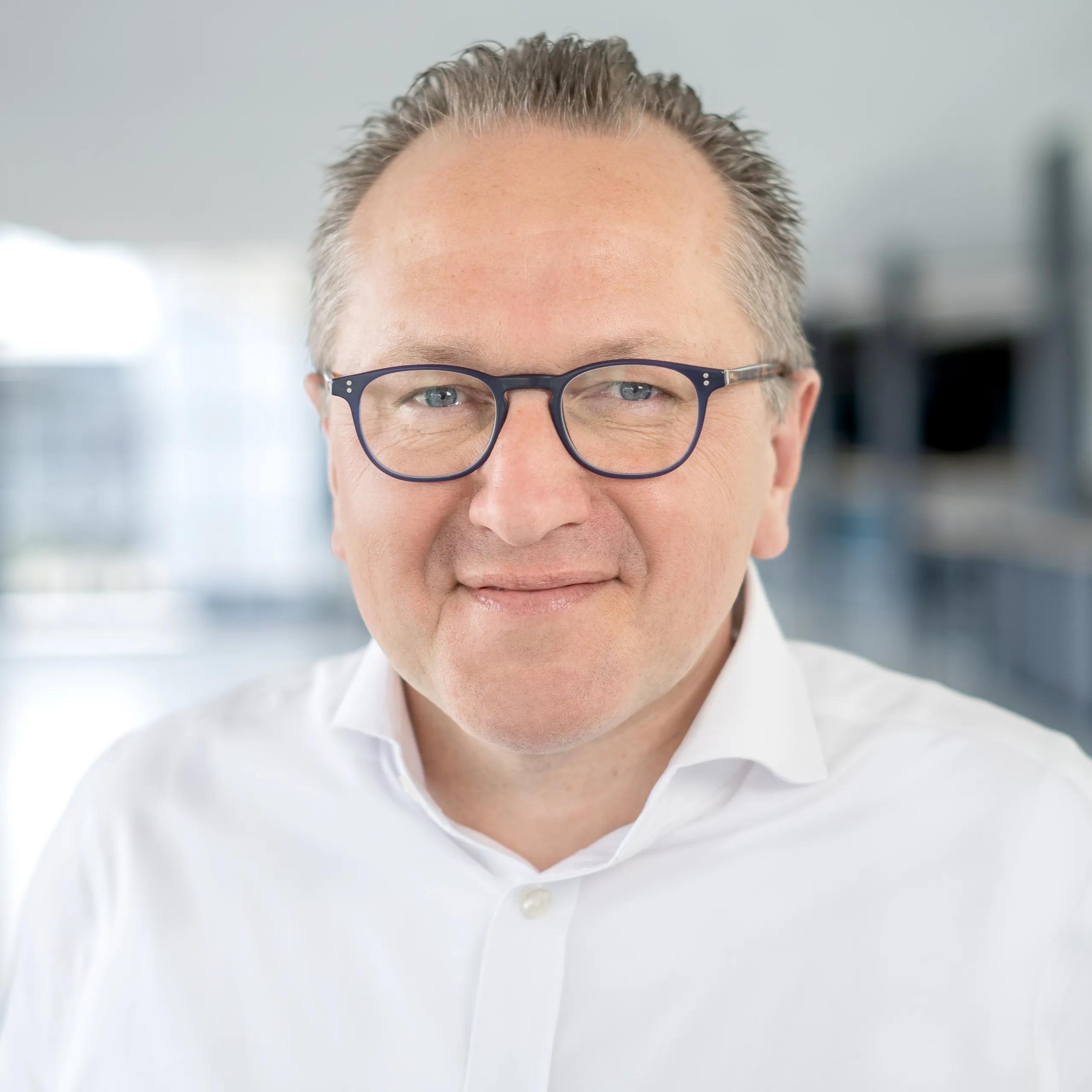 a man wearing glasses and a white shirt