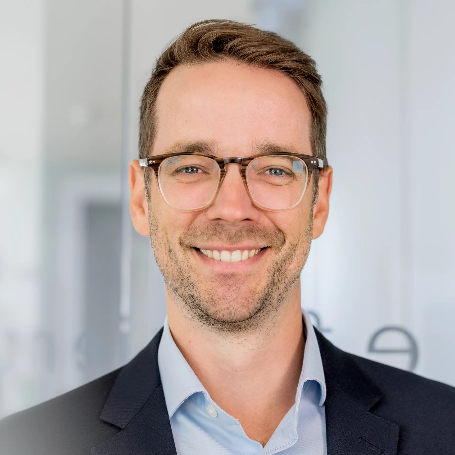 a man wearing glasses and a suit