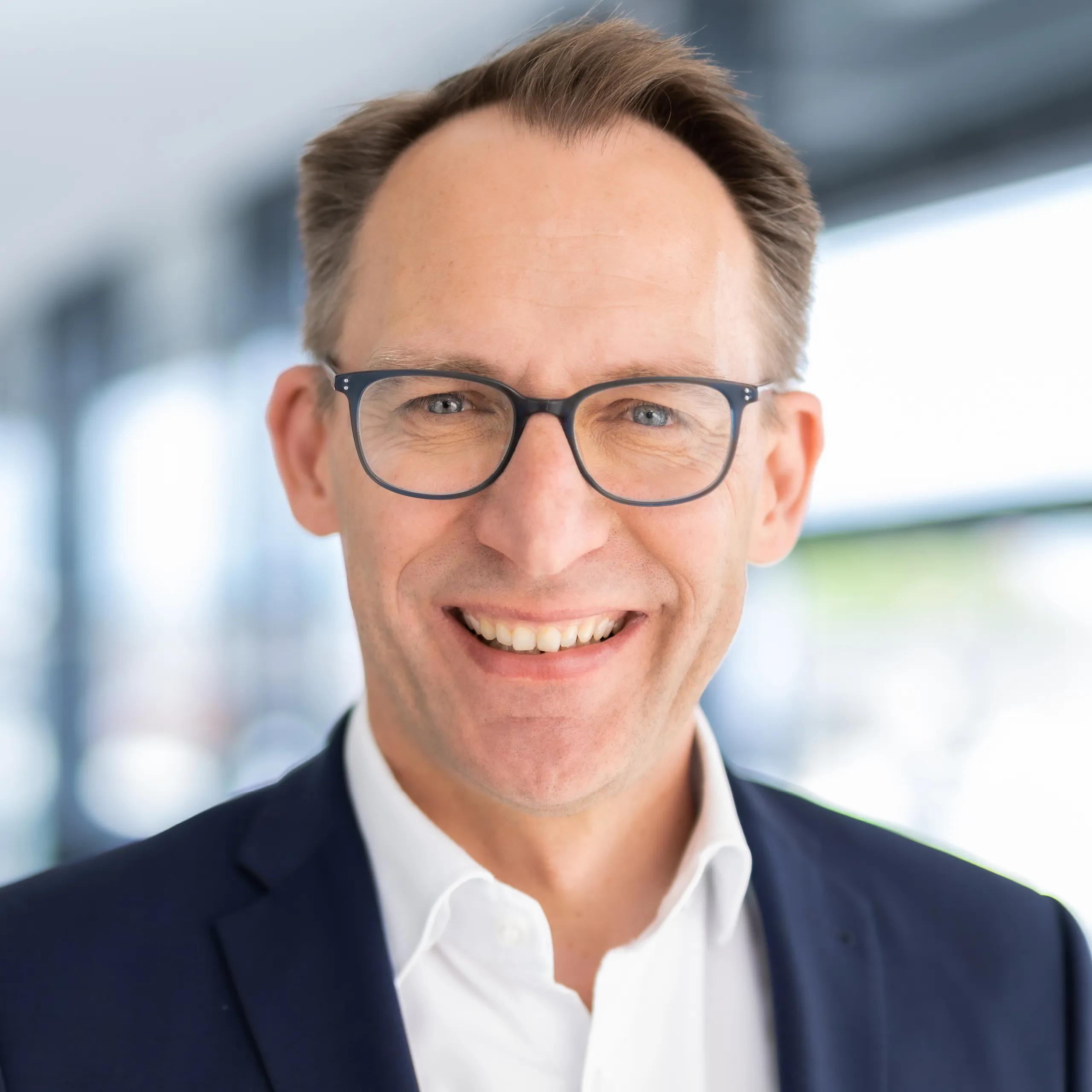 a man wearing glasses and a suit