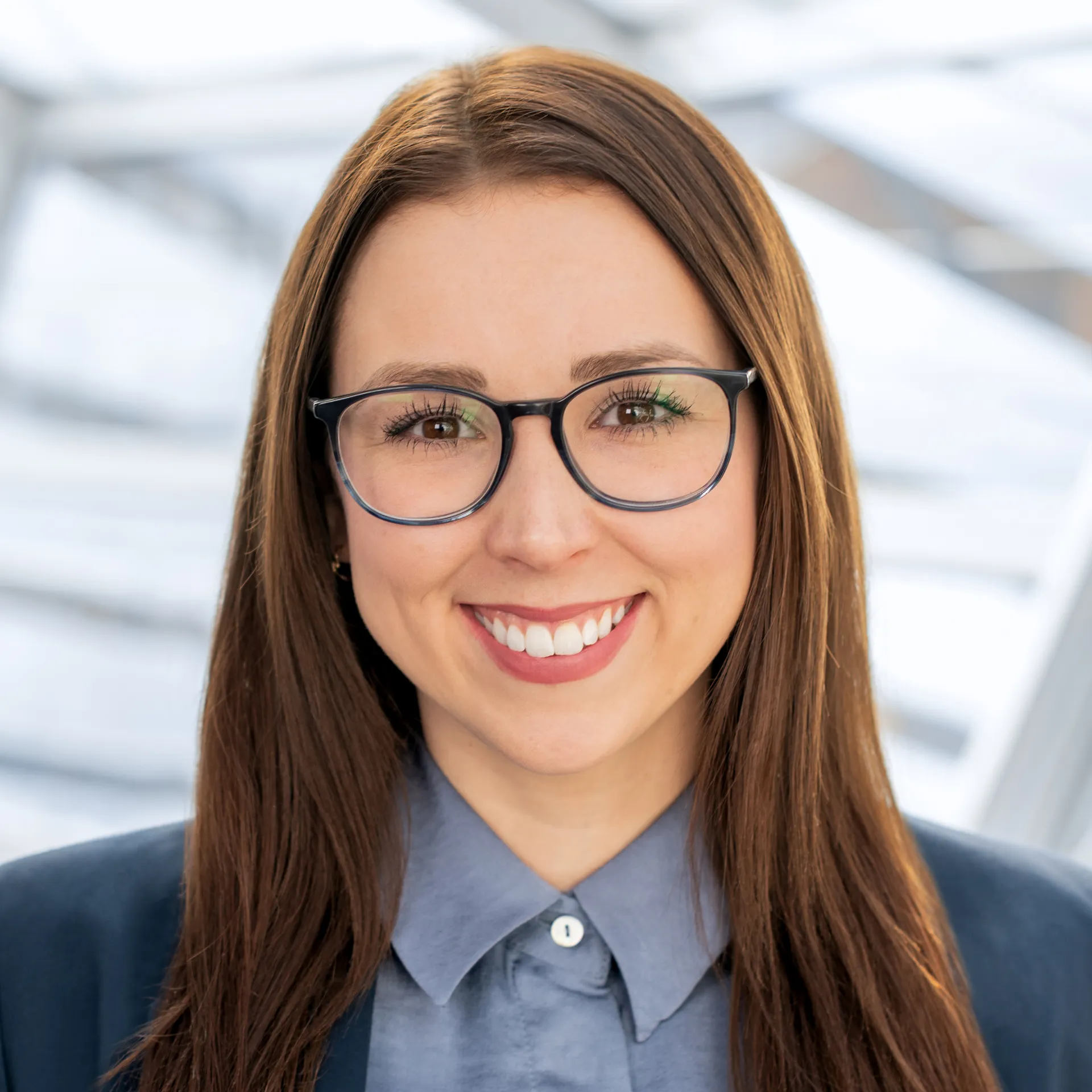 a woman wearing glasses and smiling