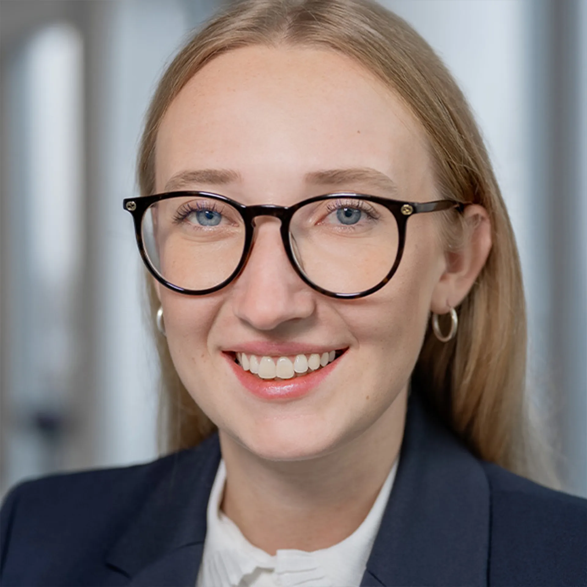 a woman wearing glasses and smiling