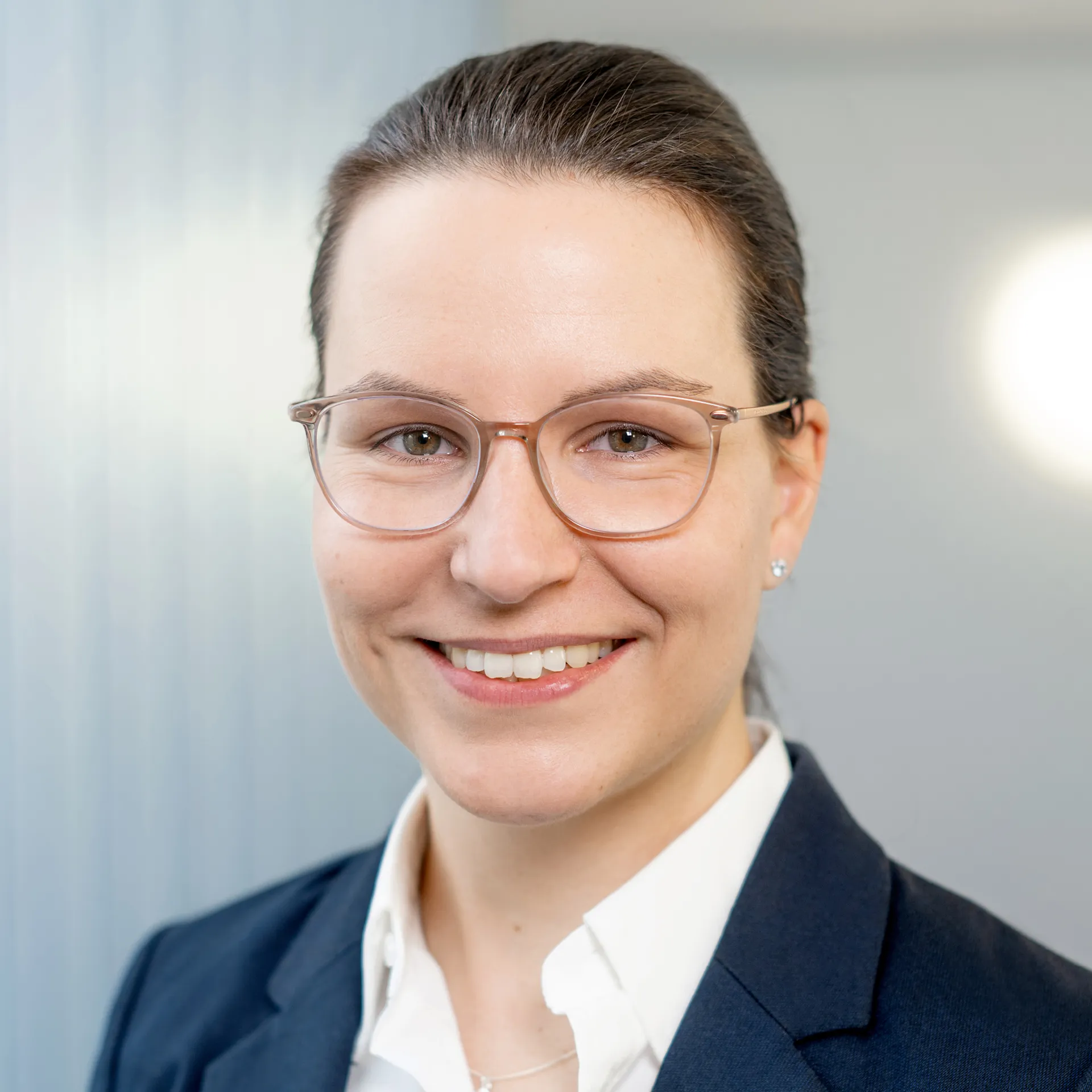 a woman wearing glasses and smiling