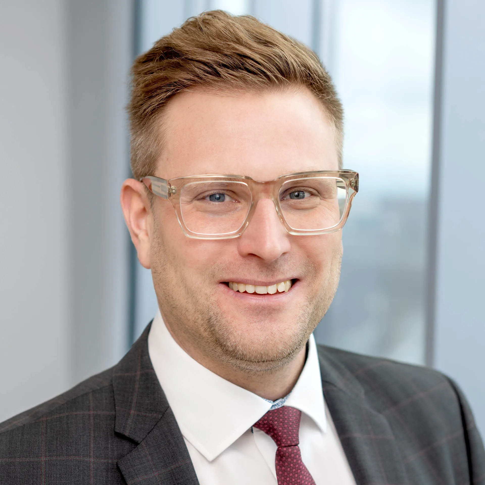 a man wearing glasses and a suit