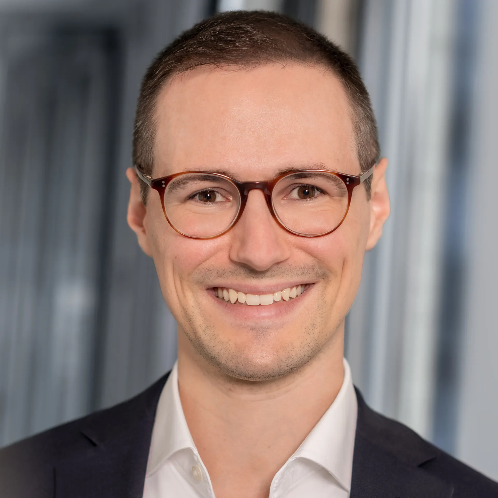 a man wearing glasses and smiling